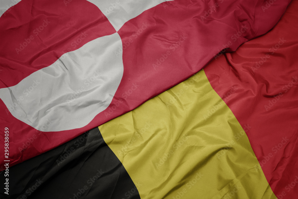 waving colorful flag of belgium and national flag of greenland. waving colorful flag of belgium and national flag of greenland.