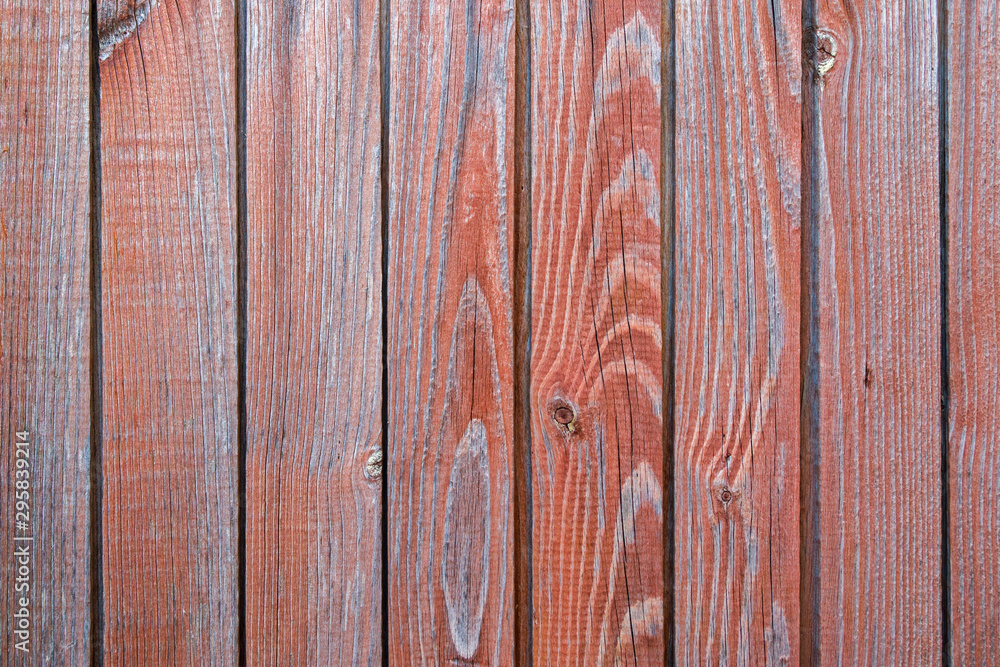 The wall or floor of wooden vertical planks of building with slats with a pattern of knots and stains with traces of cut branches painted in brown color. Natural textured wooden background.