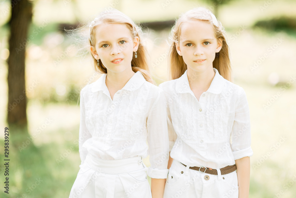 little children play in the park, two girls with long hair have rest outdoors little children play in the park, two girls with long hair have rest outdoors
