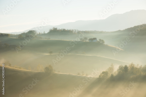 Beautiful scenery landscape Romania village mountains hills fields foggy morning first ray splitting light