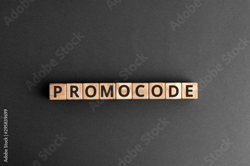 Promocode - word from wooden blocks with letters, coupon, promotion code, promo code concept,  top view on grey background photo