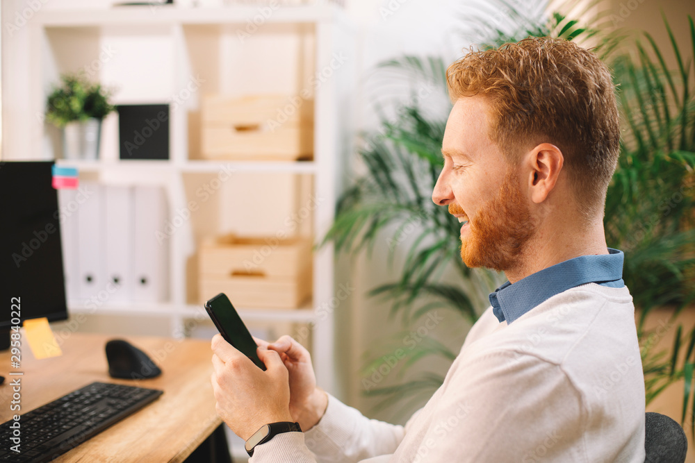 Young man using phone in office. Young man using phone in office.