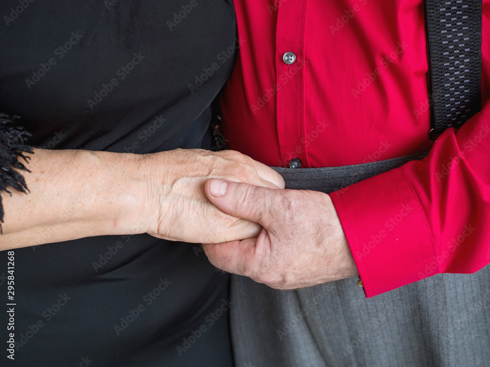Hands of an elderly couple close-up holding each other