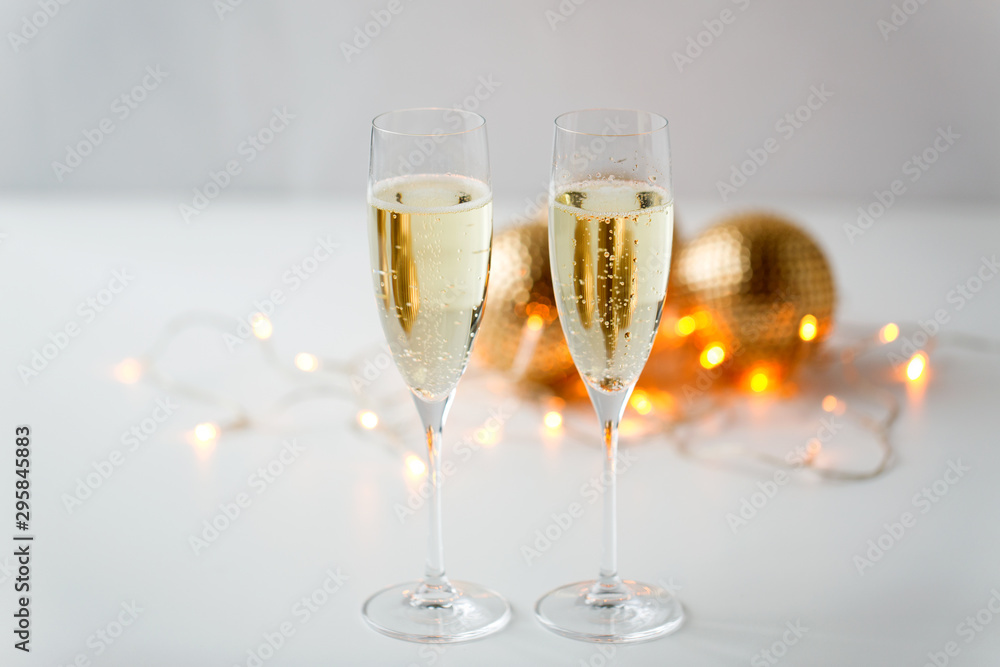 christmas, holidays and celebration concept - two glasses of champagne and decorations christmas, holidays and celebration concept - two glasses of champagne and decorations
