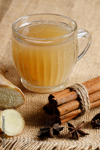 Ginger tea in a glass with fresh sliced ginger and cinnamon