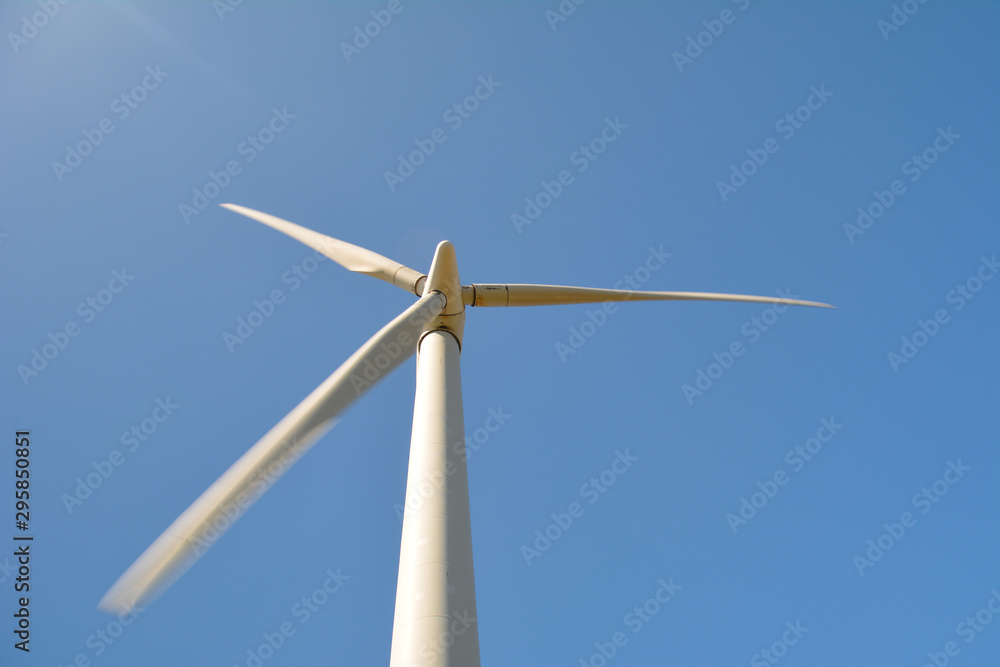 Close-up and low angle view of spinning blades of a wind turbine Close-up and low angle view of spinning blades of a wind turbine