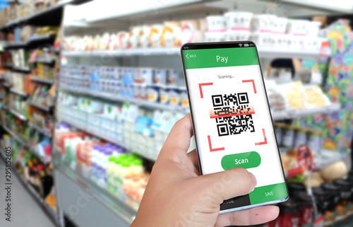Hand holding smartphone to scan QR code payment , online shopping , cashless technology .