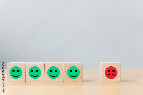 Wooden block with icon face emotion happiness and sadness, Unique, think different, individual and standing out from the crowd concept