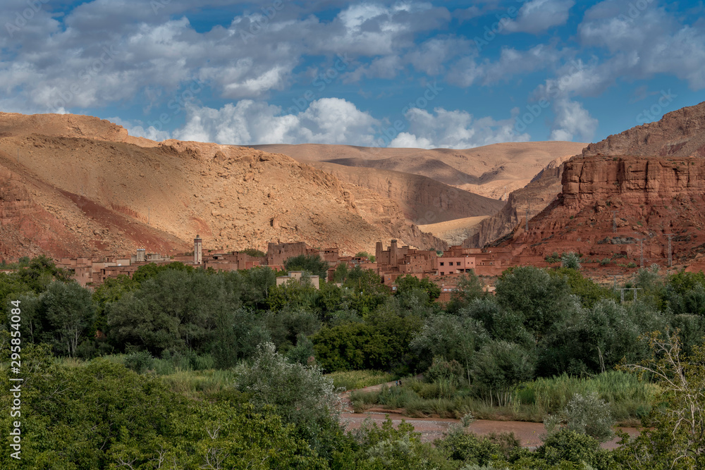 Moroccan berber village with mountains, river, desert, mountains and lush vegetation
