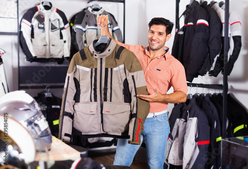 Male customer is demonstrating modern jacket that he choose