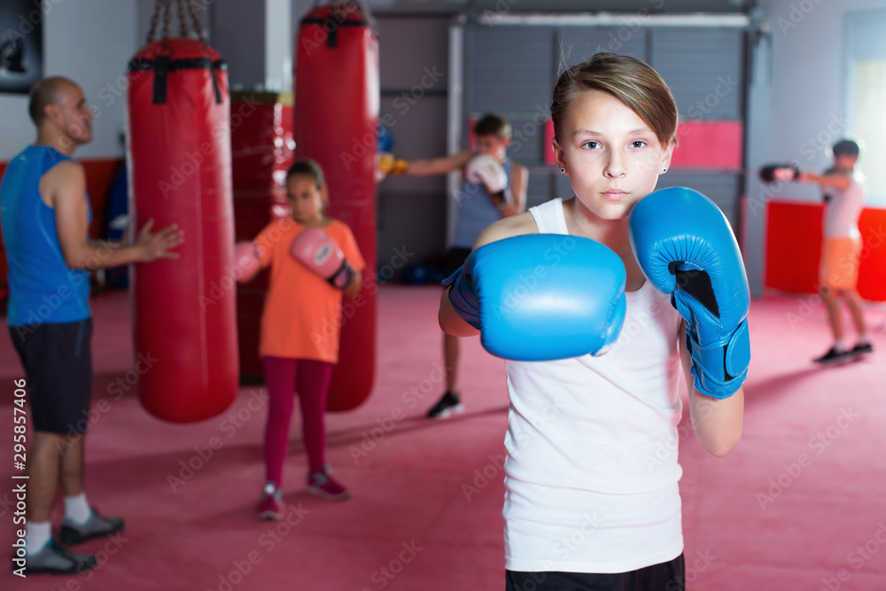 Child boxer in gloves posing during boxing