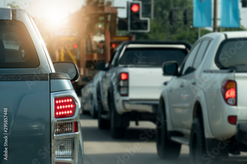 Luxury of pickup gray car stop on the junction by traffic light control in across. Traveling in the provinces during the bright period. Open light brake. with many cars.