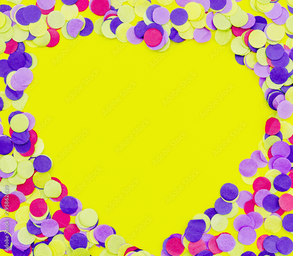 Heart shaped colorful confetti on yellow background