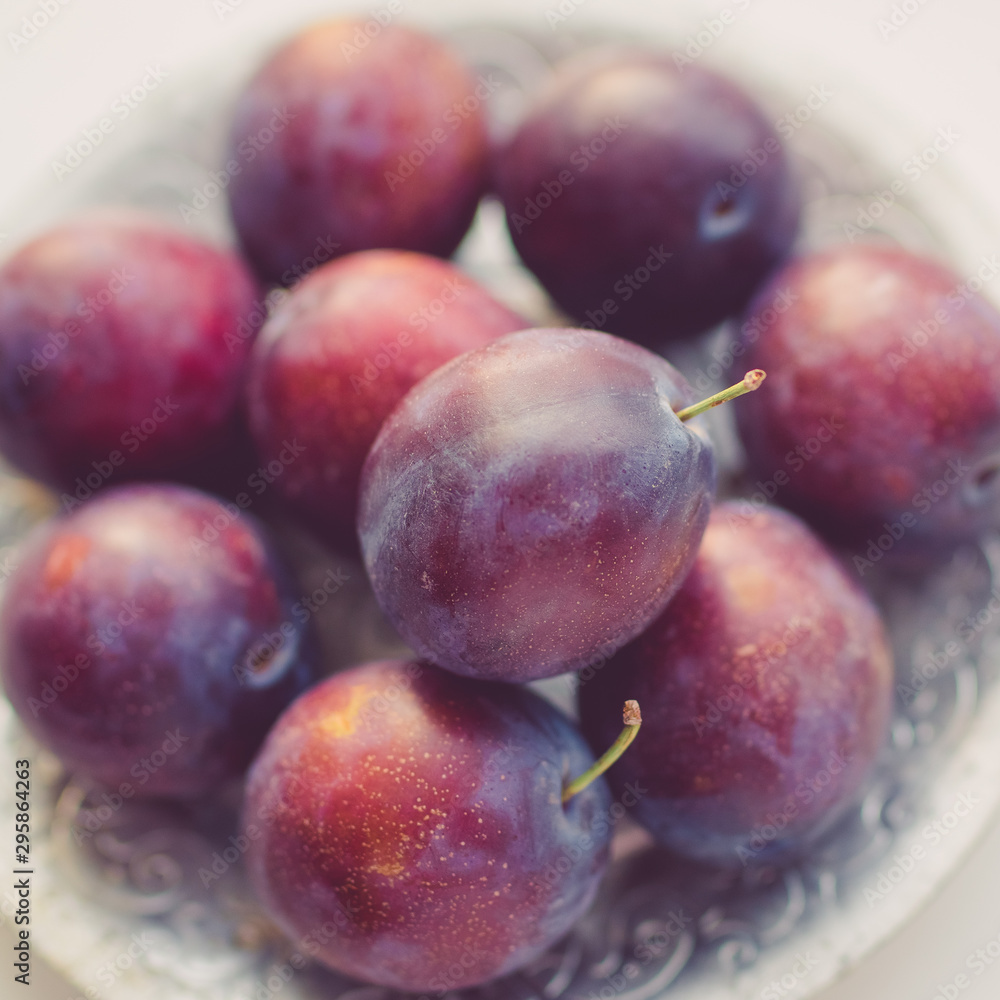 Ripe purple plums in a silver plate closeup. Ripe purple plums in a silver plate closeup.