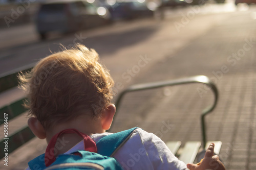 Little boy on his back runs away with his backpack photo