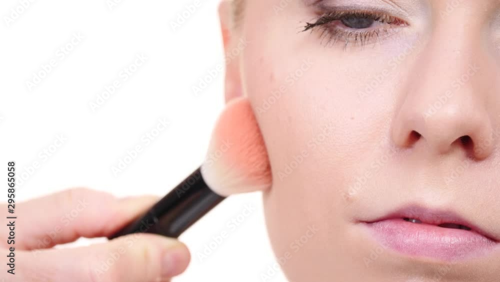 Woman face painting. Makeup artist applying blush bronzer with brush to model cheek. Cosmetic beauty procedures and makeover concept. Slow motion Woman face painting. Makeup artist applying blush bronzer with brush to model cheek. Cosmetic beauty procedures and makeover concept. Slow motion
