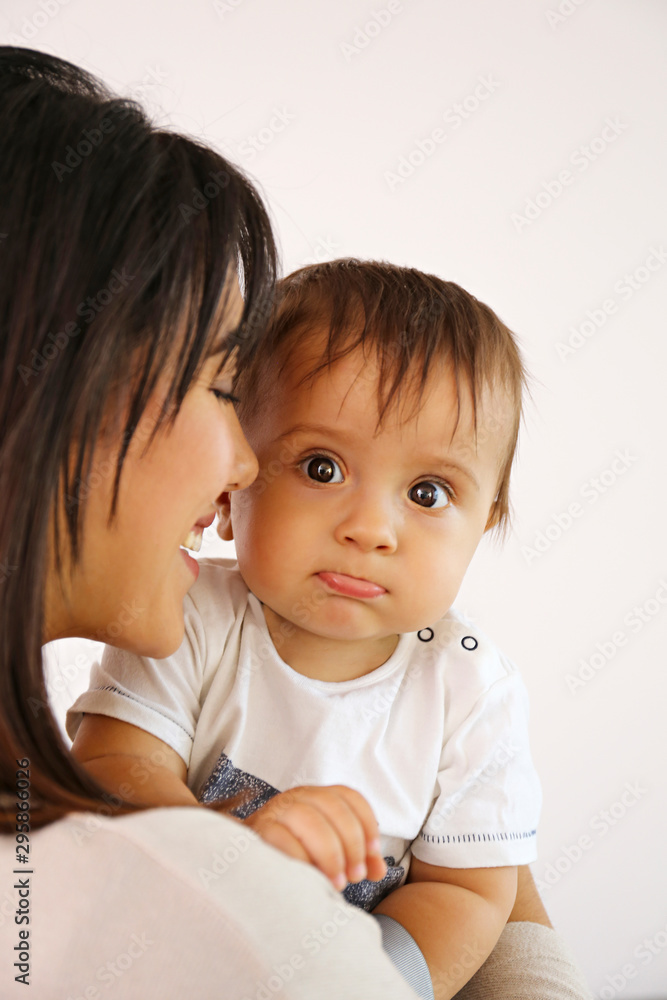 Portrait of young mother taking care of her little son at home. Beautiful female with straight brunette hair playing with child at living room. Close up, copy space, background. Portrait of young mother taking care of her little son at home. Beautiful female with straight brunette hair playing with child at living room. Close up, copy space, background.