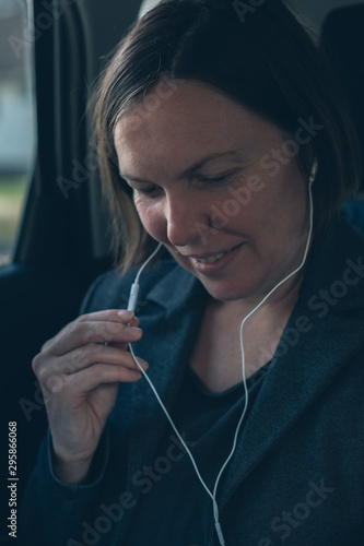 Businesswoman dictating into smartphone earphones microphone