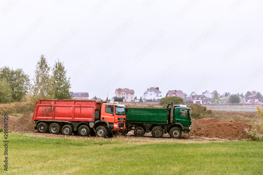 Two large 70-ton dump trucks brought sand to the site to add to the new construction site Two large 70-ton dump trucks brought sand to the site to add to the new construction site