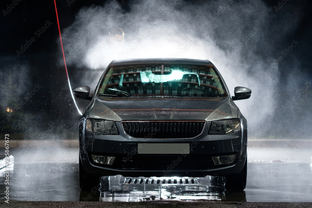 Obraz premium Car close-up. Car wash. Manual car wash with pressurized water in car wash outside. 