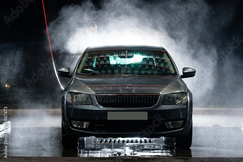 Car close-up. Car wash. Manual car wash with pressurized water in car wash outside. 