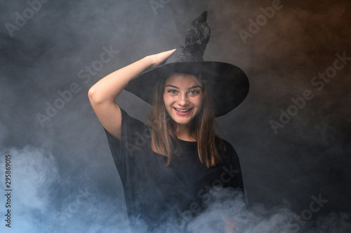 Young witch holding black and orange air balloons for halloween parties