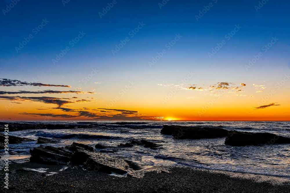 Rocky Shoreline at Sunset over Ocean