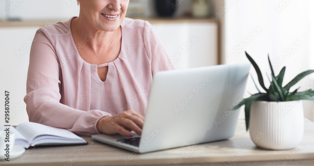 Cropped image of senior business woman working with laptop Cropped image of senior business woman working with laptop