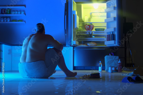a fat man on a diet wants to eat and at night stands near the   refrigerator, render 3D