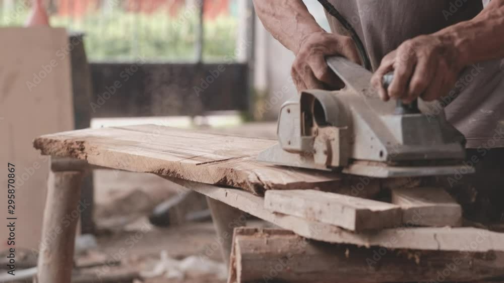 Slow motion of craftsman use polishing machine to make splat is smooth and the machine split some pieces of wood in workplace during day time. Slow motion of craftsman use polishing machine to make splat is smooth and the machine split some pieces of wood in workplace during day time.