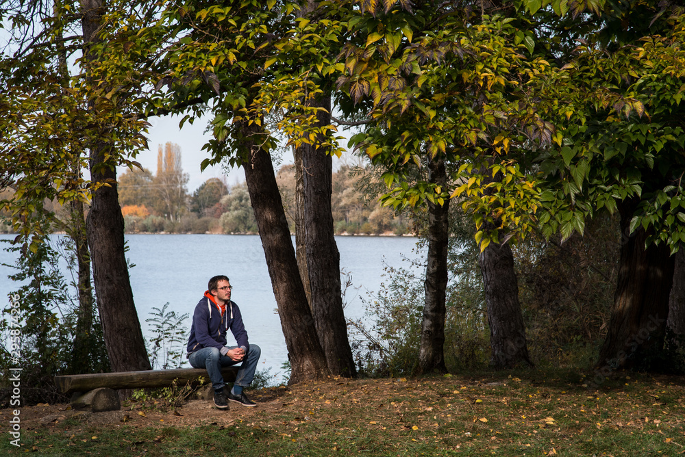 Fototapeta premium un homme dépressif au chômage assis en automne dans un parc pour réfléchir à sa vie