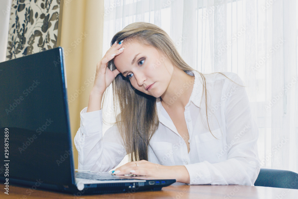 Headache in the workplace from restarting work. Stress at work. The girl holds her head from fatigue and headache. Headache in the workplace from restarting work. Stress at work. The girl holds her head from fatigue and headache.