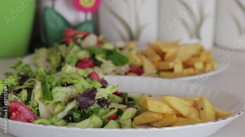 Potato fries and salad on plate