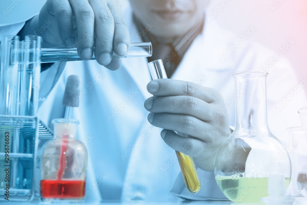 Scientist testing some chemical sample at laboratory with lab glassware on the table. Science research and development new innovation technology concept. Scientist testing some chemical sample at laboratory with lab glassware on the table. Science research and development new innovation technology concept.