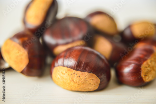 Castagne mature appena raccolte su tagliere bianco