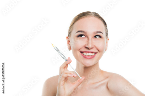 A young girl holds a syringe with a birevitalizant. Lip augmentation.
