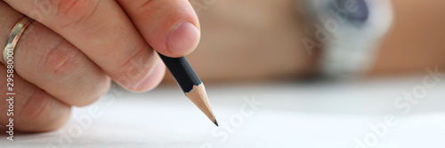 Male arm holding black simple pencil ready to draw