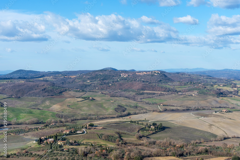 Fototapeta premium Picturesque winter landscape view of Tuscany with stone houses, colorful hills, fields and vineyards in Italy.