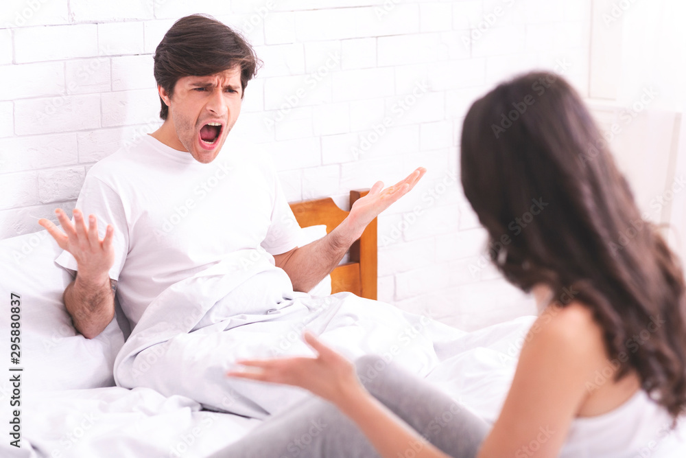 Obraz premium Emotional spouses screaming at each other in bed