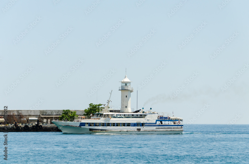 A white passenger ship enters the port in the summer. A white passenger ship enters the port in the summer.