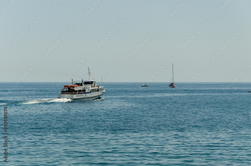 White passenger ship goes to sea in the summer.