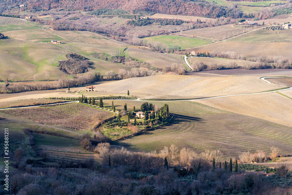 Fototapeta premium Picturesque winter landscape view of Tuscany with stone houses, colorful hills, fields and vineyards in Italy.