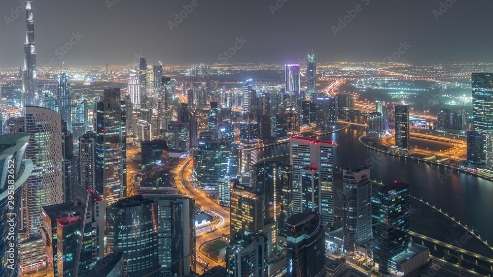 Panoramic aerial view of business bay towers in Dubai night timelapse.
