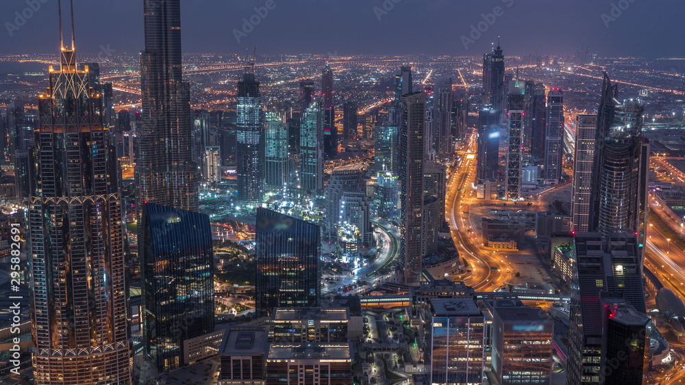 Dubai Downtown skyline futuristic cityscape with many skyscrapers and Burj Khalifa aerial night to day timelapse.