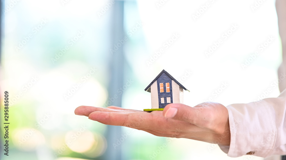 Side view a house model in a hands. Side view a house model in a hands.