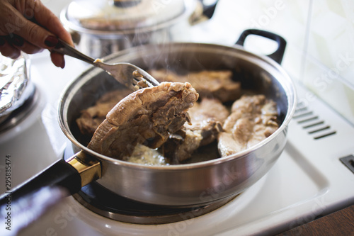 Pork chop is fried in a pan stock photo
