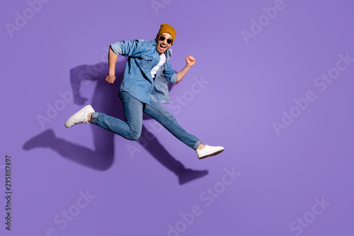 Full length body size photo of excited cheerful ecstatic handsome surprised amazed astonished guy sportive running towards discounted store isolated over vivid color purple background photo