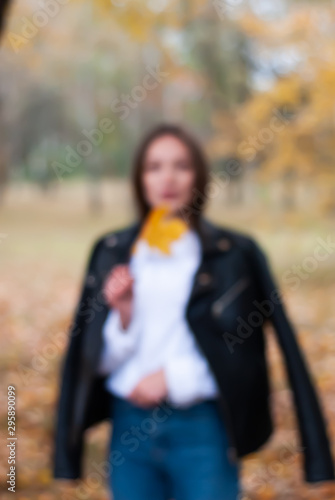 blurry shot of young girl walking in autumn Park,
