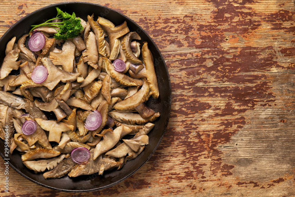 Delicious fried mushrooms in pan on table Delicious fried mushrooms in pan on table