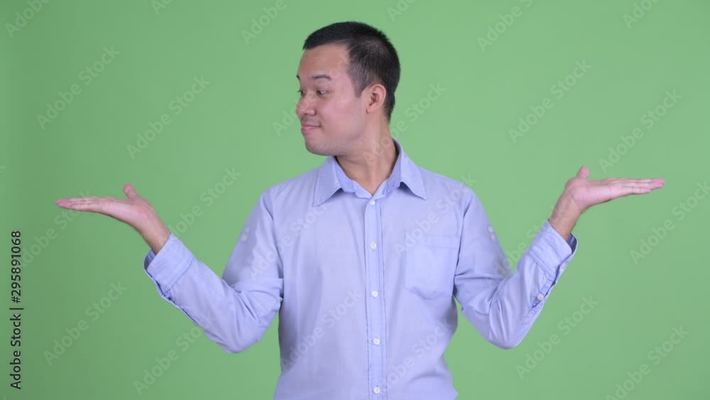 Happy Asian businessman comparing something Happy Asian businessman comparing something